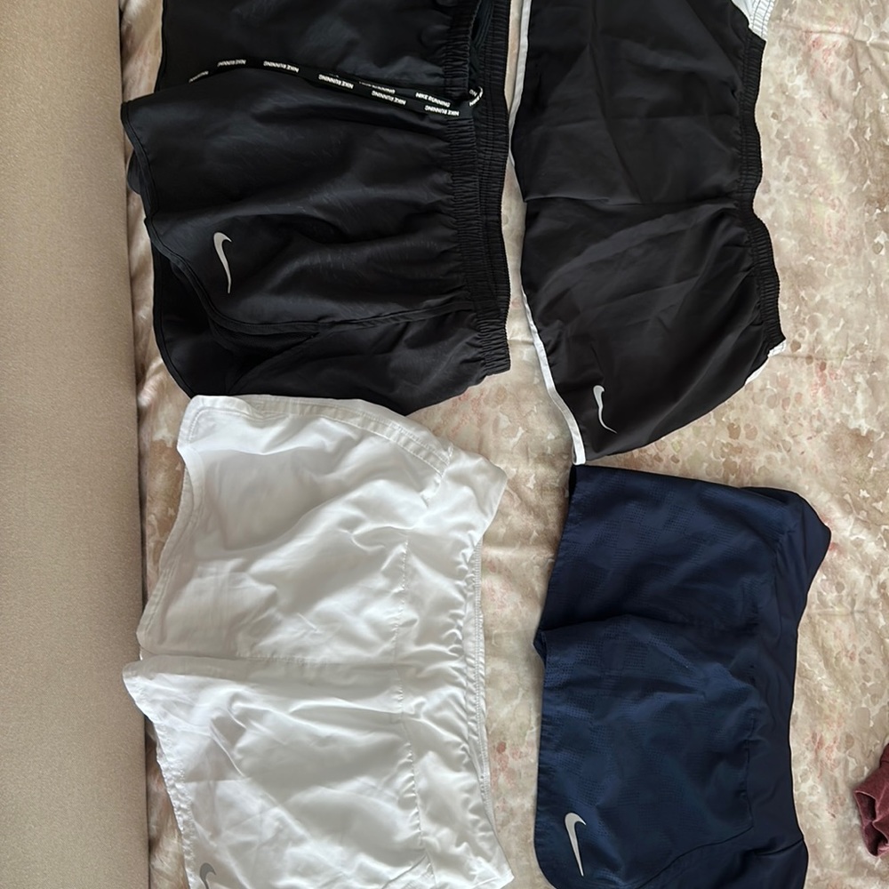 Four pairs of Nike shorts; black/white, black, white, navy.